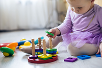 Baby putting rings on a stick
