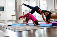 mother and young daughter doing yoga