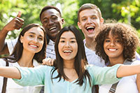 Multi ethnic teens friends taking selfie picture outdoors