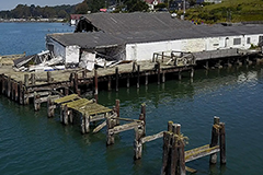 image of a dilapidated pier extending over a body of water. 