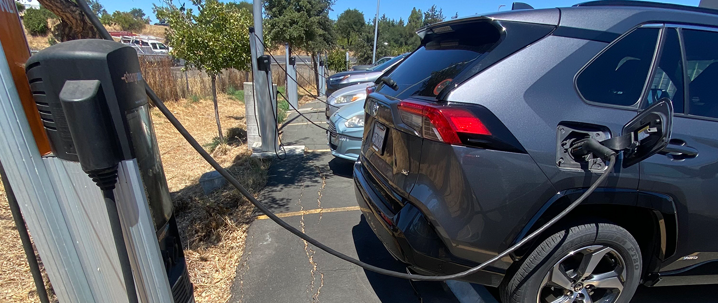 image of an electric vehicle connected to a charge station