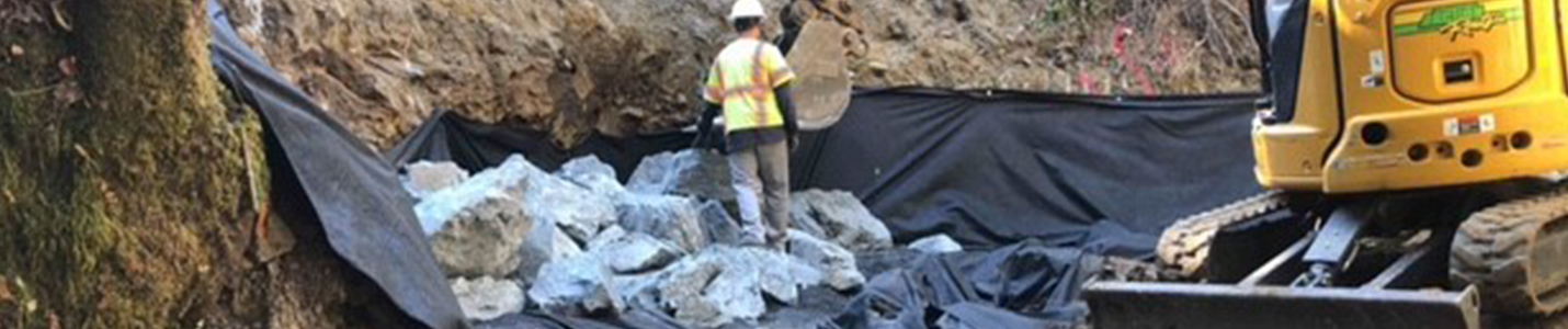 construction worker on work site installing riprap