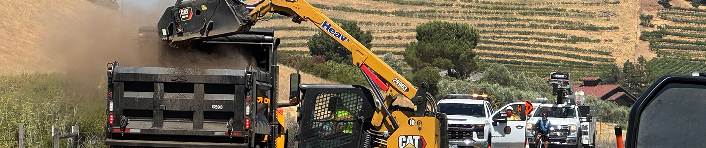 construction vehicles and workers paving a road
