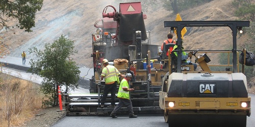 construction workers and vehicles repairing a road
